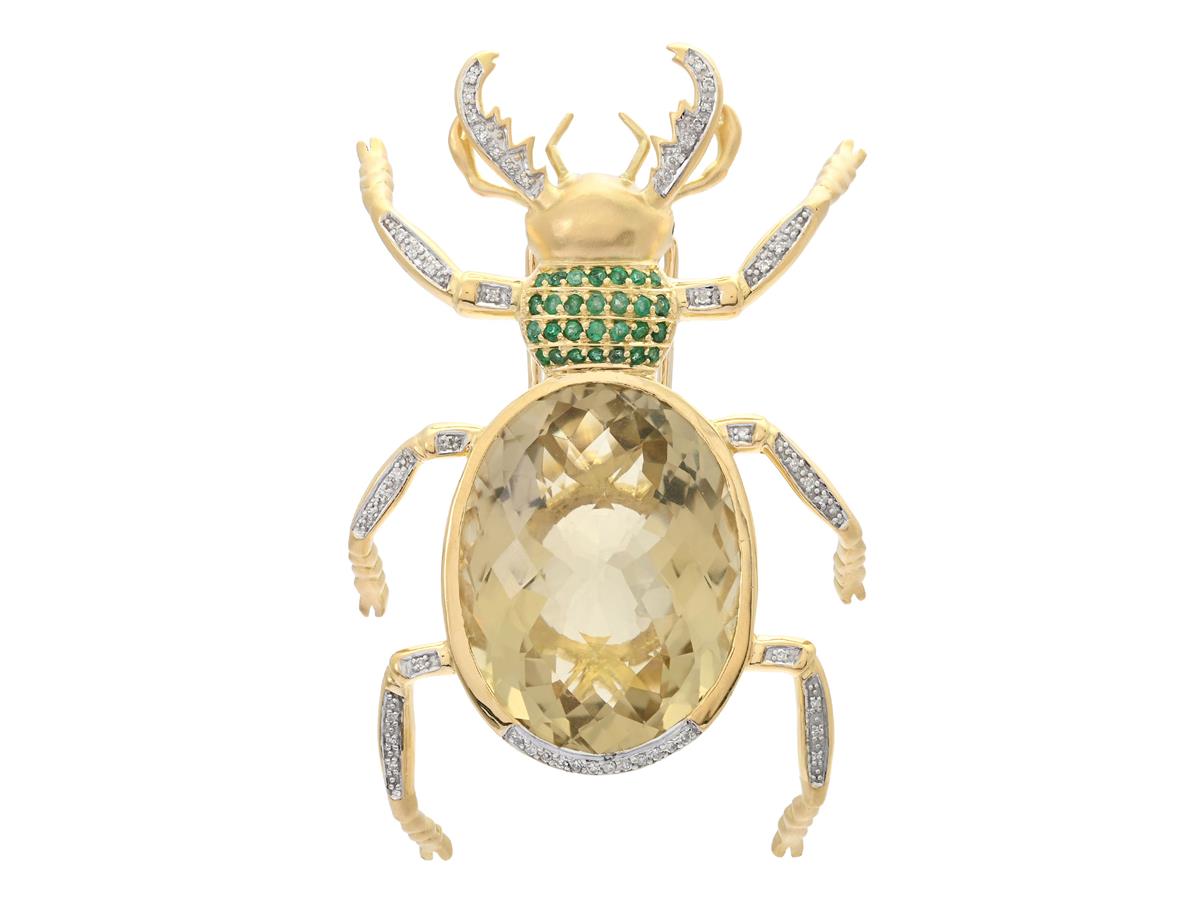 BROSCH, 18K guld, delvis matterat, i form av en ekoxe, briolettslipad citrin ca 50,00 ct, 28 smaragder, 2 rubiner, 50 åttkantslipade diamanter ca 0,27 ctv, längd ca 7,2 cm, vikt 43,2 g, några stenar med nagg och slitage, citrinen sitter något löst.