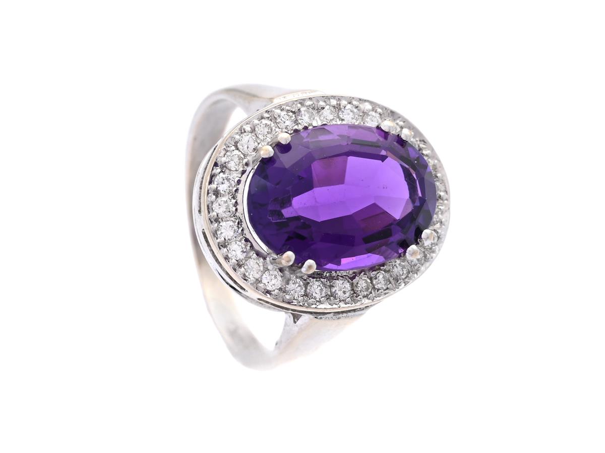 CARMOSÉRING, 18K vitguld, ovalslipad ametist, 27 briljantslipade diamanter ca 0,27 ctv, ca TW-TCr/VS, stl 16,75 mm, vikt 5,4 g, ametisten med lätt slitna fasettkanter.