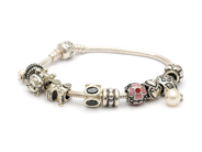 Smycken, ARMBAND, sterlingsilver med 9 berlocker, i auktion: Moderna – Lördag 14 juni 2014