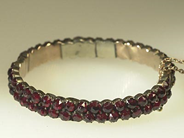 Smycken, GRANATARMBAND i vit metall, öppningsbart, i auktion: Klassiska – Lördag 24 april 2004