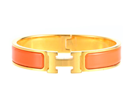 ARMRING, HERMÈS, Clic H Bracelet, guldpläterad, orange emalj, diameter 5,5 cm, smyckespåse. på auktion i Stockholm, Stockholms län hos Kaplans Auktioner