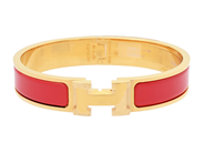 HERMÈS, ARMRING, Clic Clac H Bracelet, röd emalj, guldfärgade beslag, bredd 1 cm, diameter 5,5 cm, smyckespåse på auktion i Stockholm, Stockholms län hos Kaplans Auktioner