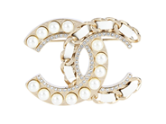 CHANEL, BROSCH, Logo CC, guldfärgad metall, vita imitationspärlor, läder, stenar, 4x5 cm, vikt 22 g, märkt B19 på auktion i Stockholm, Stockholms län hos Kaplans Auktioner
